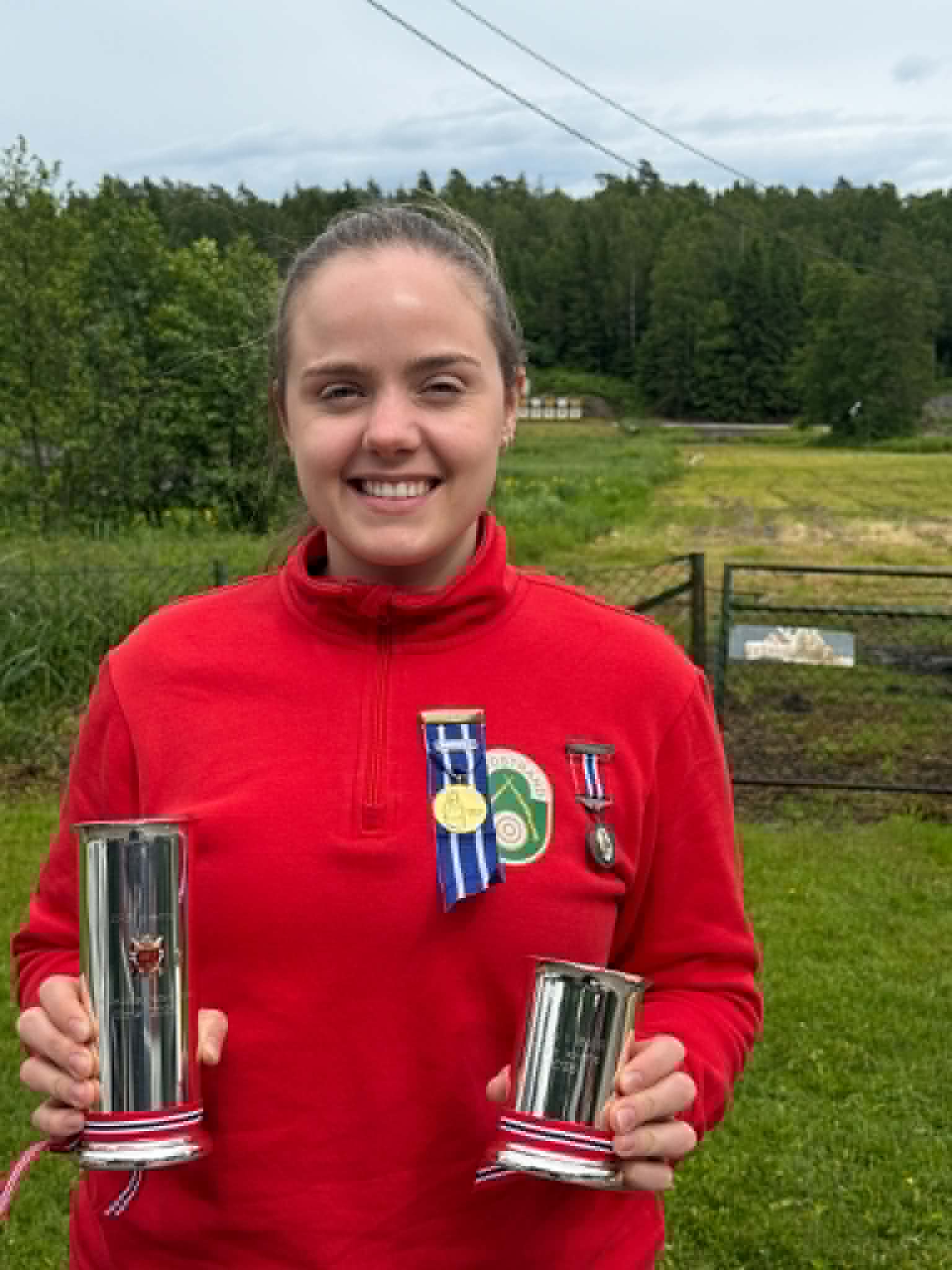 Jenny med pokaler og medaljer ute.jpg